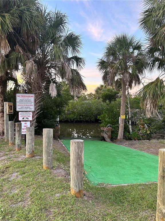 A green ramp leads to a small waterway surrounded by palm trees and mangroves — 16907 ACAPULCO ROAD, PUNTA GORDA, FL