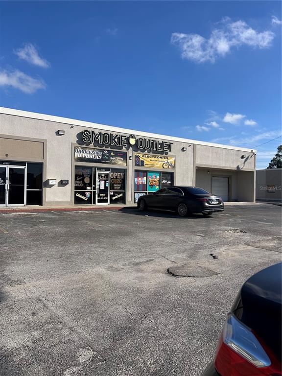 A Smoke Outlet storefront with a parked car in a paved parking lot — 5819 N 56TH STREET UNIT 1, TAMPA, FL