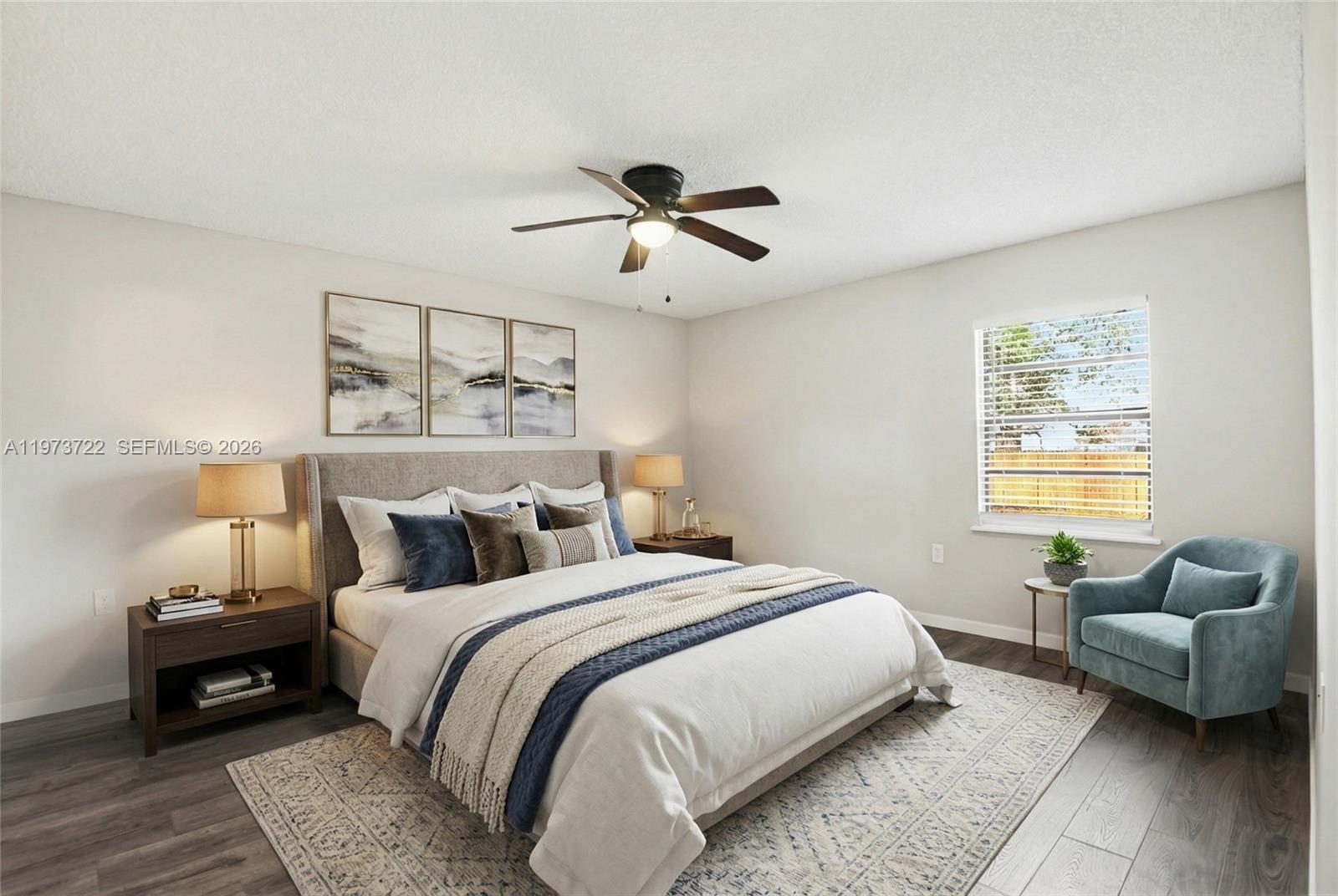 A bedroom features a bed with blue accents, a ceiling fan, and a blue armchair — 637 Mosquero Ave, Deltona FL 32738, DELTONA, FL