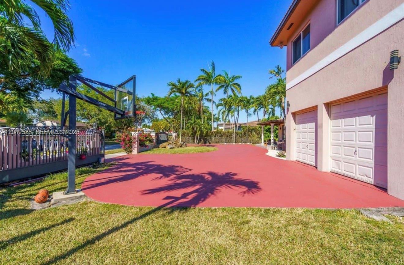 A red-paved driveway features a basketball hoop and a two-car garage next to a house — 3135 SW 80th Ave, Miami FL 33155, MIAMI, FL