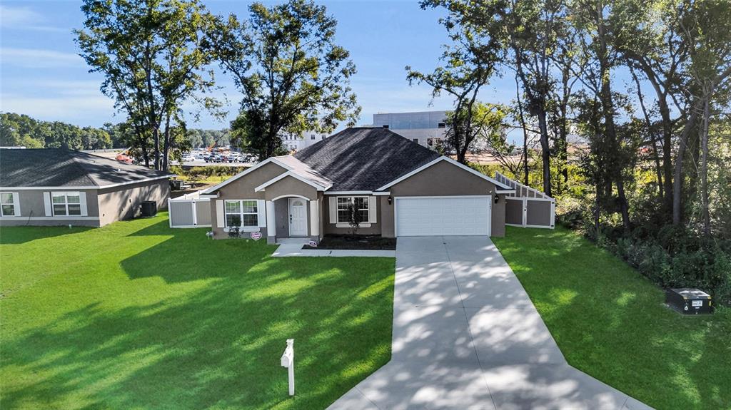 An aerial view of a single-story suburban house with a driveway and a grassy lawn — 1645 SW 168TH LOOP, OCALA, FL