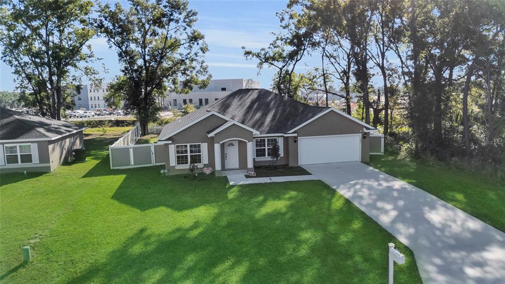 An aerial view of a single-story suburban house with a gray exterior and concrete driveway — 1645 SW 168TH LOOP, OCALA, FL