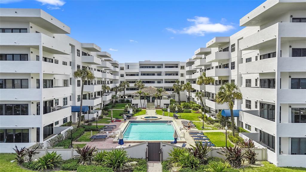 An aerial view shows a multi-story apartment complex surrounding a central swimming pool area — 330 SE 20th Avenue # 416, Deerfield Beach FL 33441, DEERFIELD BEACH, FL