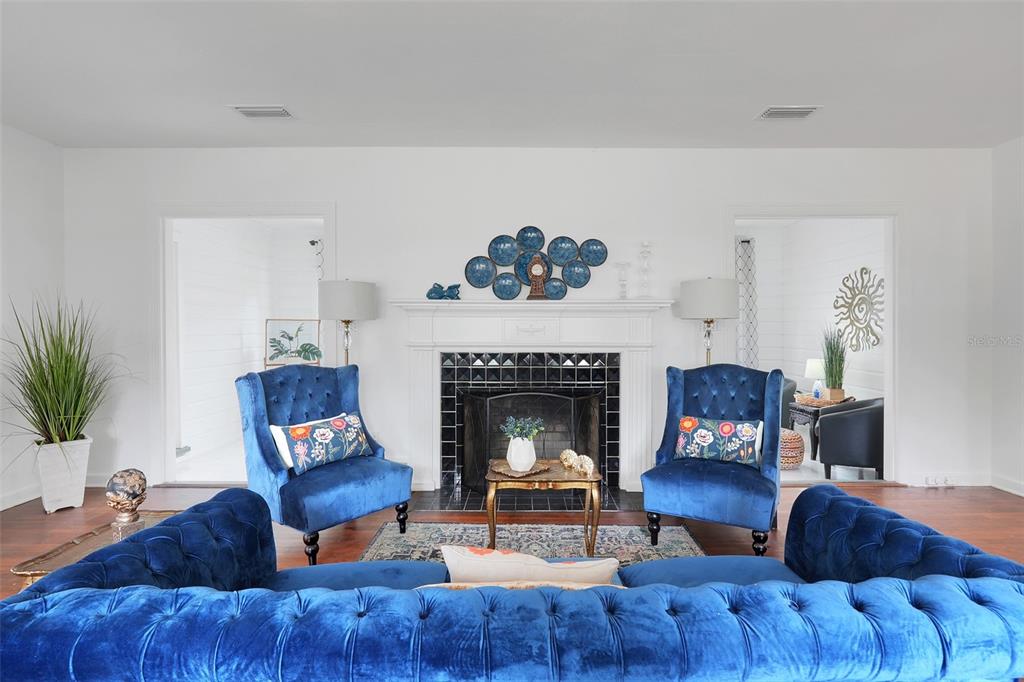 A living room features a fireplace with blue velvet furniture and a decorative wall display — 504 E CITRUS AVE, EUSTIS, FL