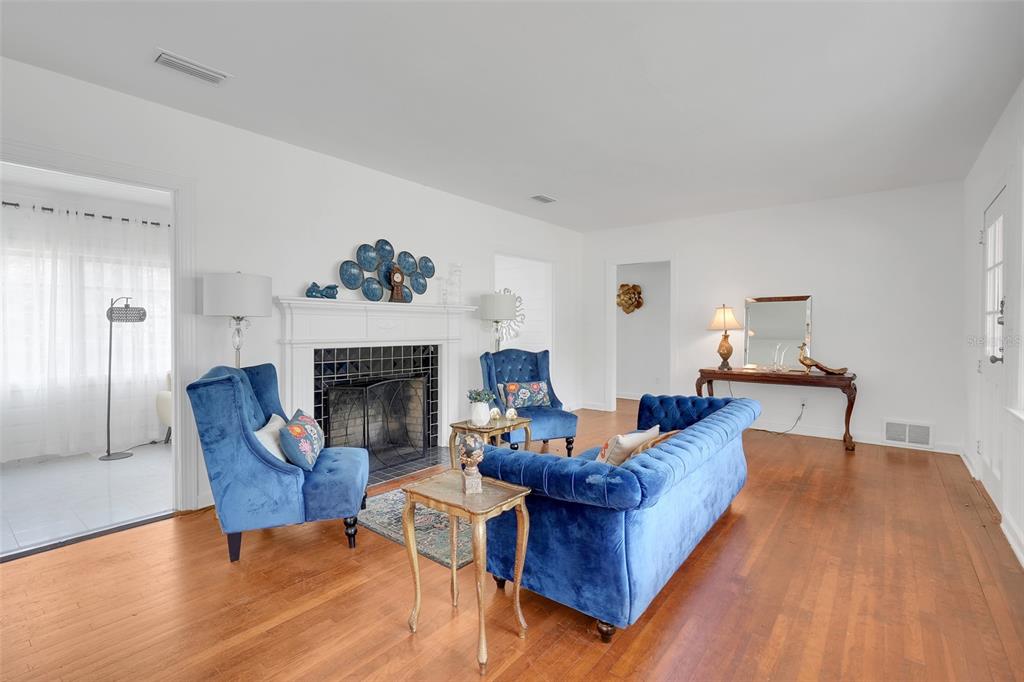 A living room features a fireplace, blue velvet furniture, and hardwood floors — 504 E CITRUS AVE, EUSTIS, FL