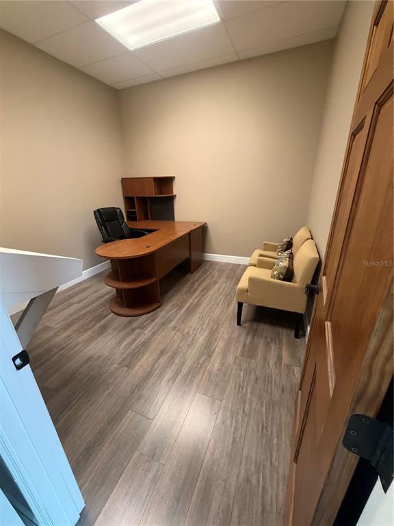 An office room features a wooden desk, two tan chairs, and wood-look flooring — 910 BELLE AVENUE UNIT 1140, WINTER SPRINGS, FL