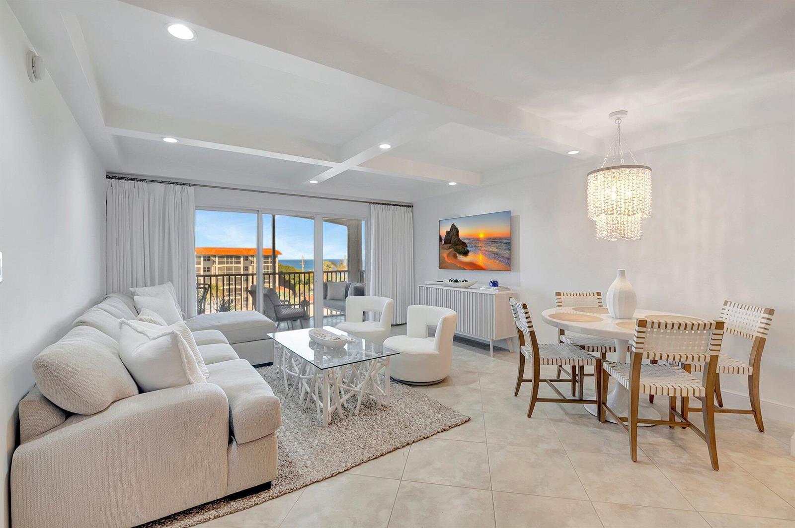 A bright living and dining area features white furniture, a glass coffee table, and balcony views — 2871 N Ocean Boulevard # D506, Boca Raton FL 33431, BOCA RATON, FL