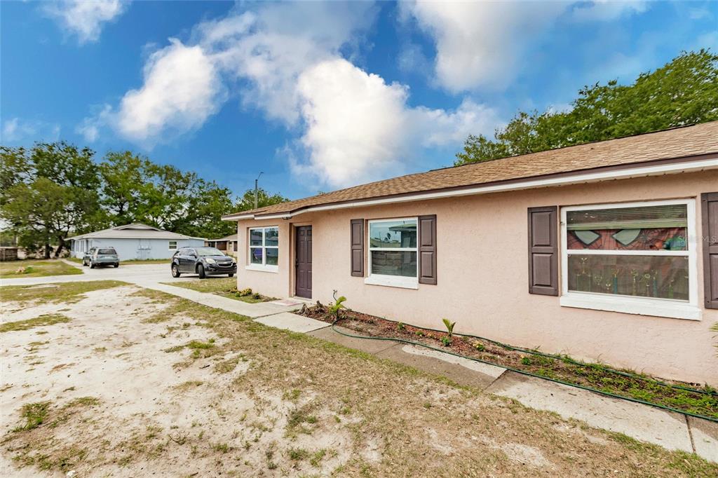 A single-story peach-colored house with a brown roof, dark shutters, and a sandy front yard — 1702 BIRCHWOOD CIRCLE, LEESBURG, FL