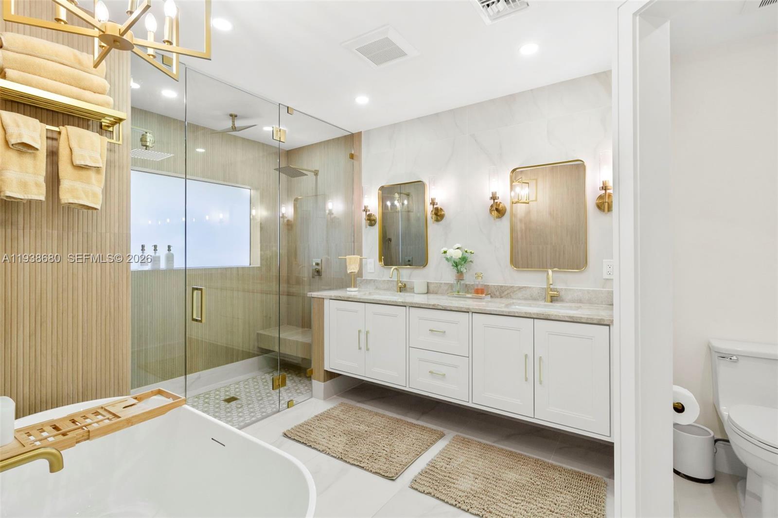 A modern bathroom features a double vanity, glass-enclosed shower, and a freestanding soaking tub — 3540 NE 28th Ave, Lighthouse Point FL 33064, LIGHTHOUSE POINT, FL