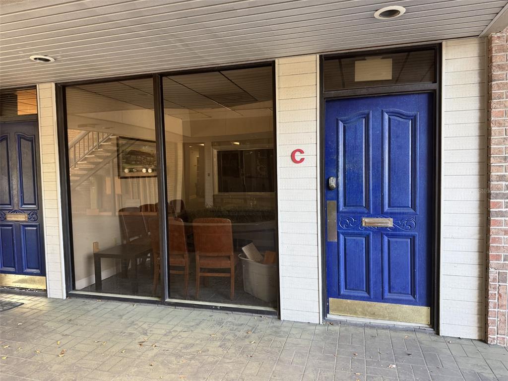 A blue door marked with a red C sits beside a large windowed office space — 2226 E SILVER SPRINGS BOULEVARD UNIT Suite C, OCALA, FL