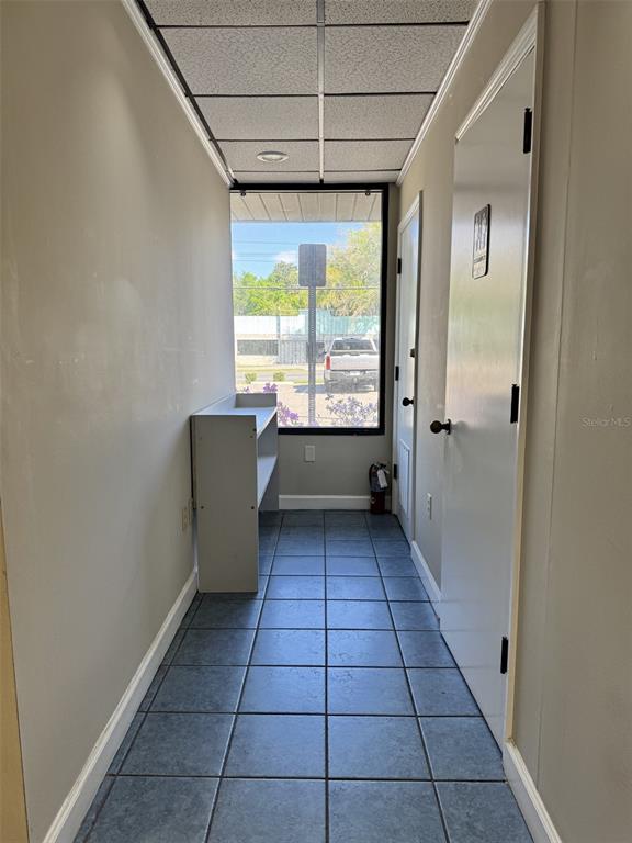 A narrow hallway with tiled flooring leads to a window overlooking a parking lot — 2226 E SILVER SPRINGS BOULEVARD UNIT Suite C, OCALA, FL