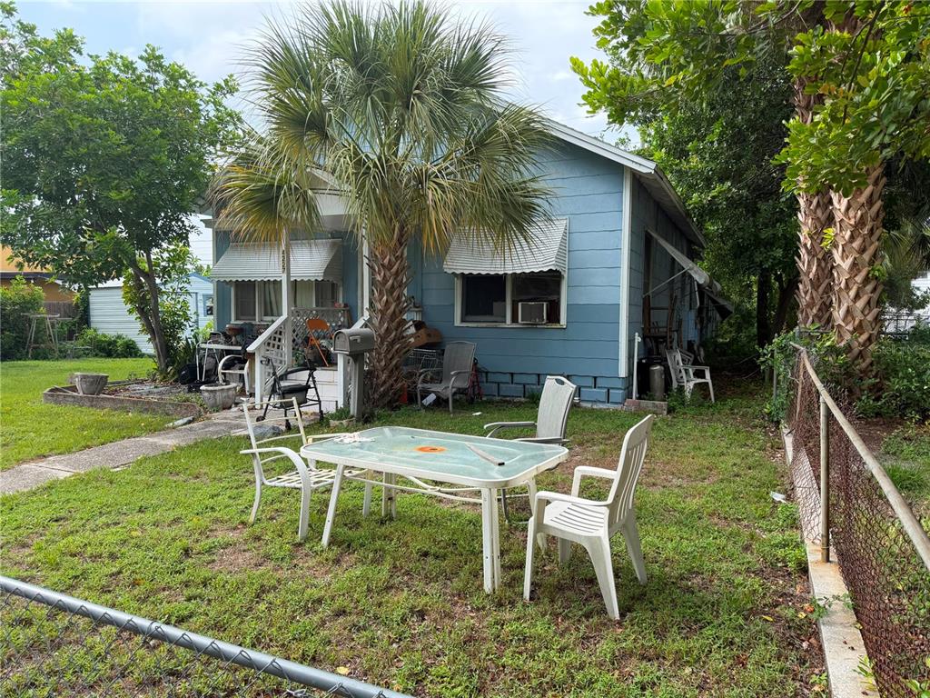A blue house with a palm tree and a patio table set in the yard — 4227 2ND AVENUE S, ST PETERSBURG, FL