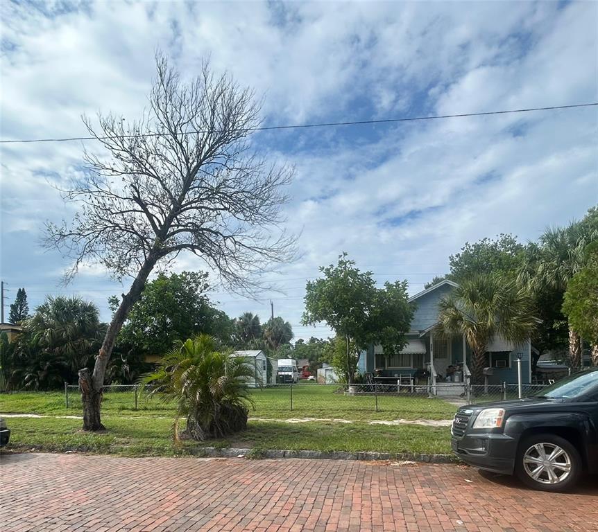 A brick street leads to a yard with a bare tree and a blue house — 4227 2ND AVENUE S, ST PETERSBURG, FL