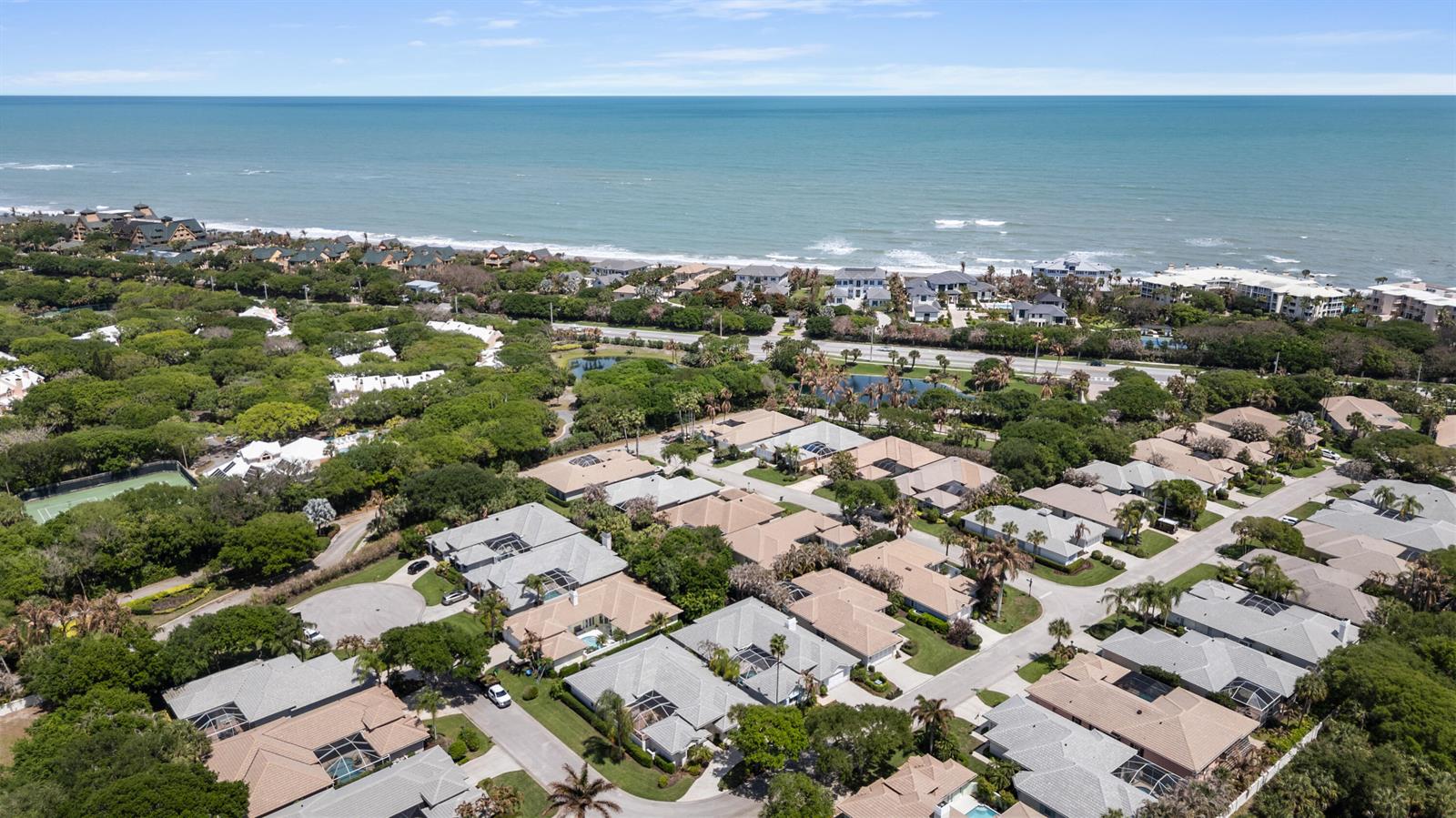 An aerial view shows a residential neighborhood with houses near a beach and ocean — VERO BEACH, FL