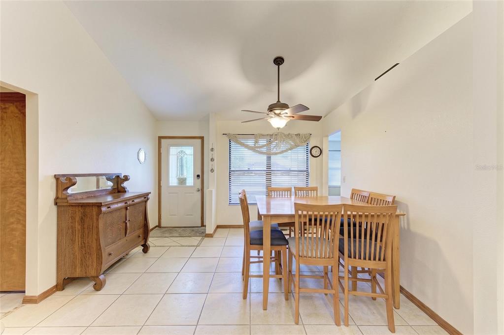 A dining room features a wooden table with six chairs, tile flooring, and a side cabinet — 2147 FLORIBANNA STREET, NORTH PORT, FL