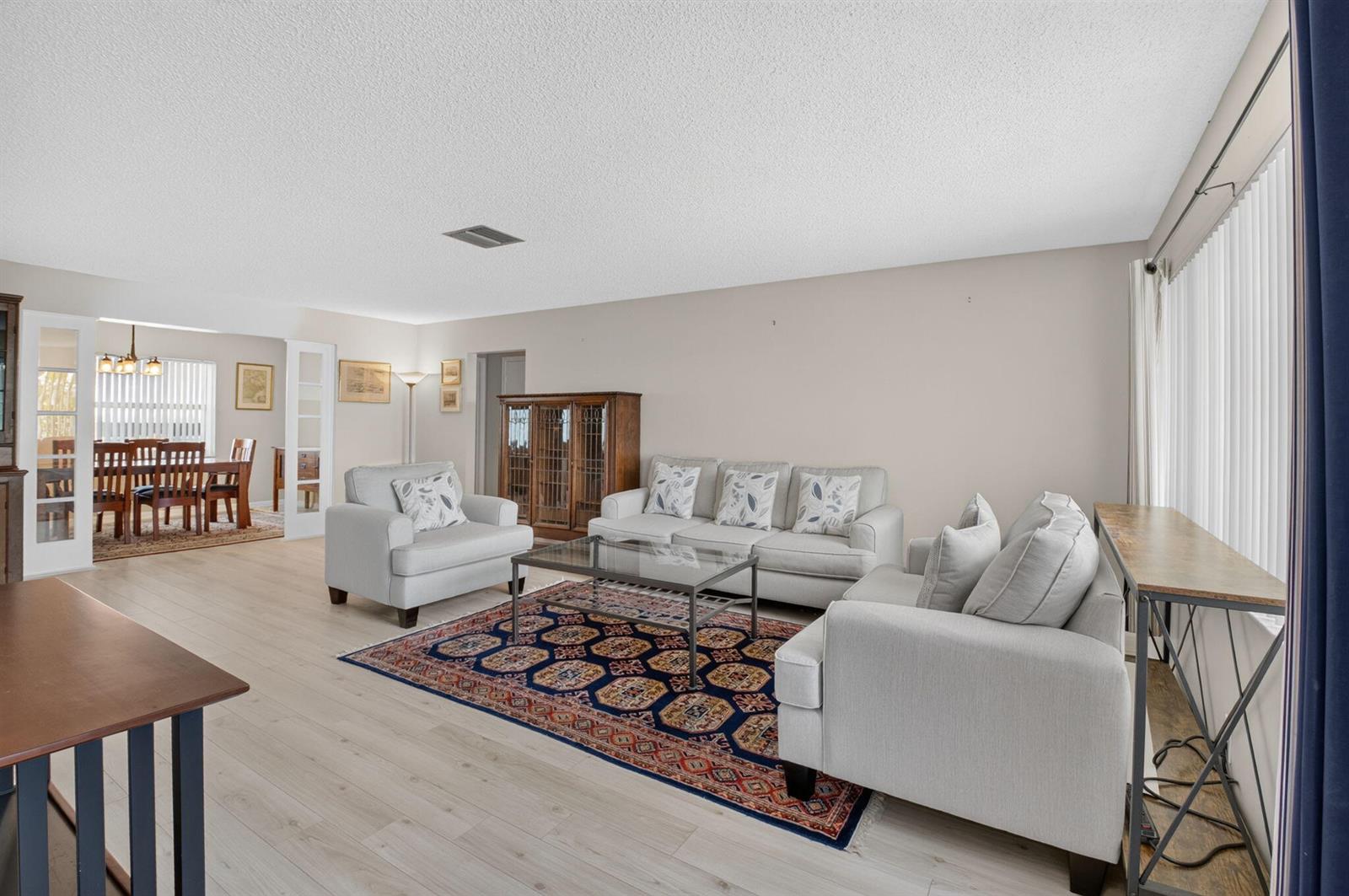 A living room with light wood floors, a patterned rug, and neutral-colored sofa seating — 1710 SW 20th Street, Boynton Beach FL 33426, BOYNTON BEACH, FL