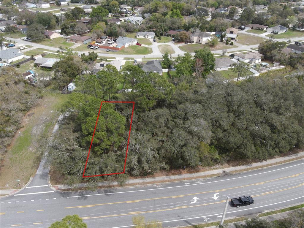 An aerial view shows a rectangular wooded lot outlined in red next to a road — 752 FORT SMITH BOULEVARD, DELTONA, FL