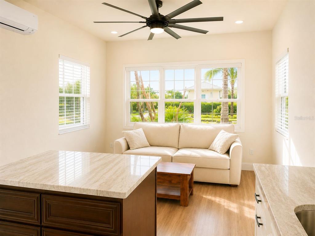 A kitchen island overlooks a living area with a beige sofa and large windows — 9459 SE 47TH WAY, WEBSTER, FL