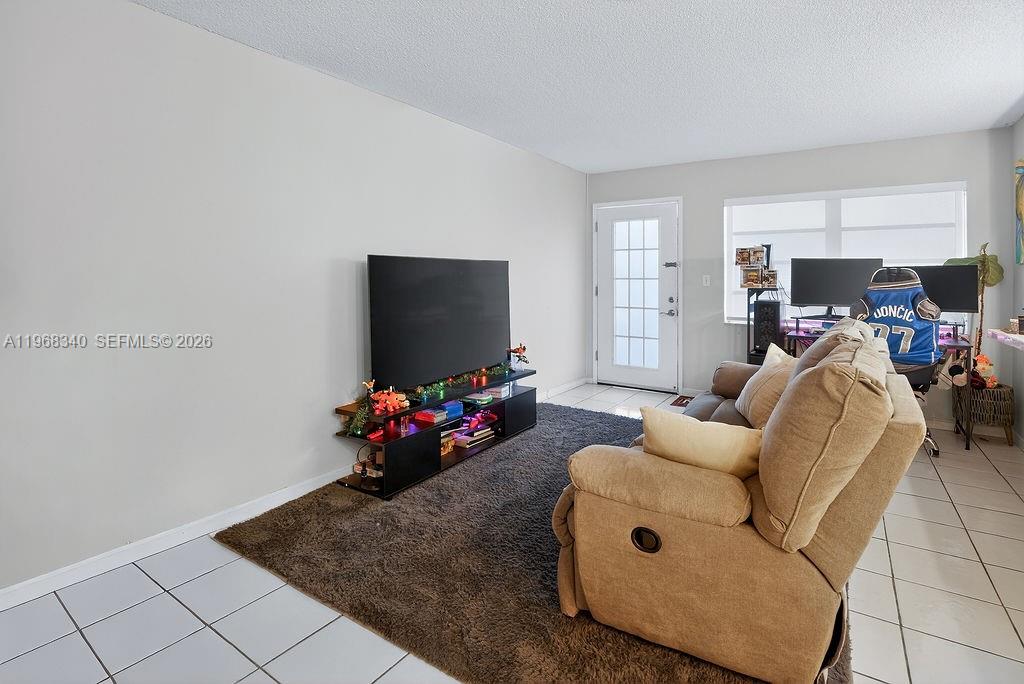 A living room features a large television on a stand, a recliner, and a desk — 20311 NE 2nd Ave # 15, Miami FL 33179, MIAMI, FL