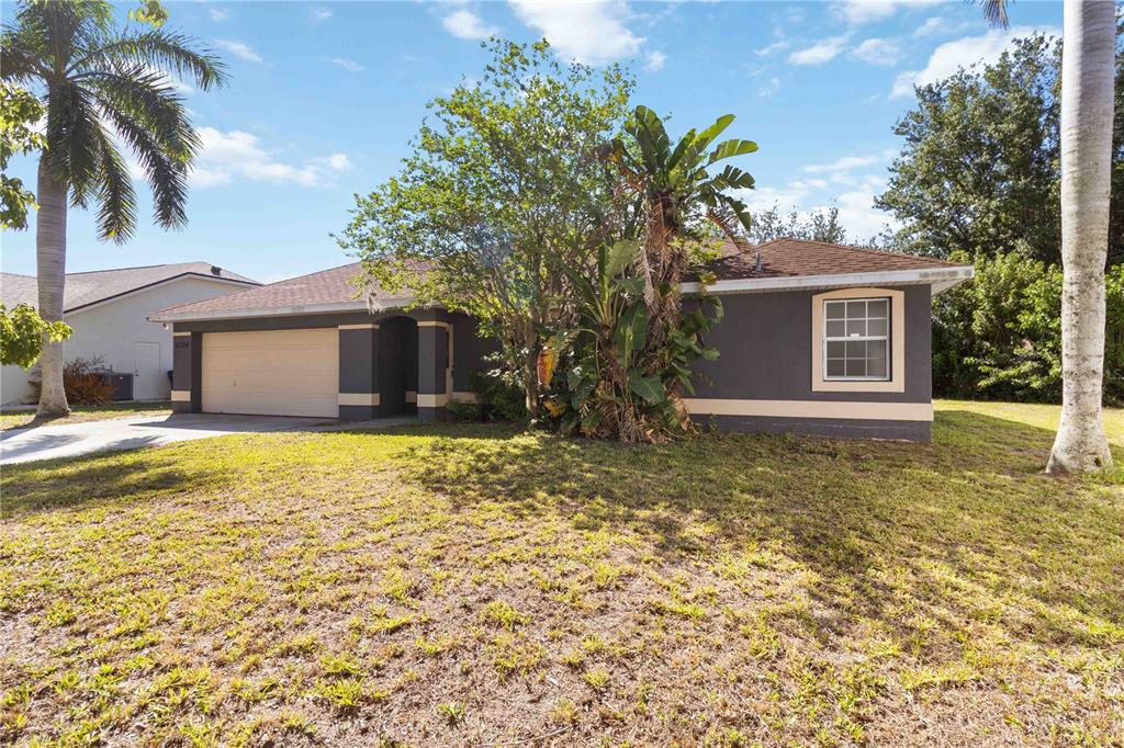 A single-story house with a dark gray exterior, tan trim, and a two-car garage — 6214 35TH AVENUE E, PALMETTO, FL