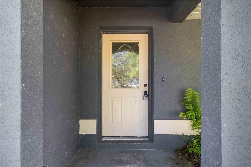A front entryway features a white door with a glass insert set in a dark wall — 6214 35TH AVENUE E, PALMETTO, FL