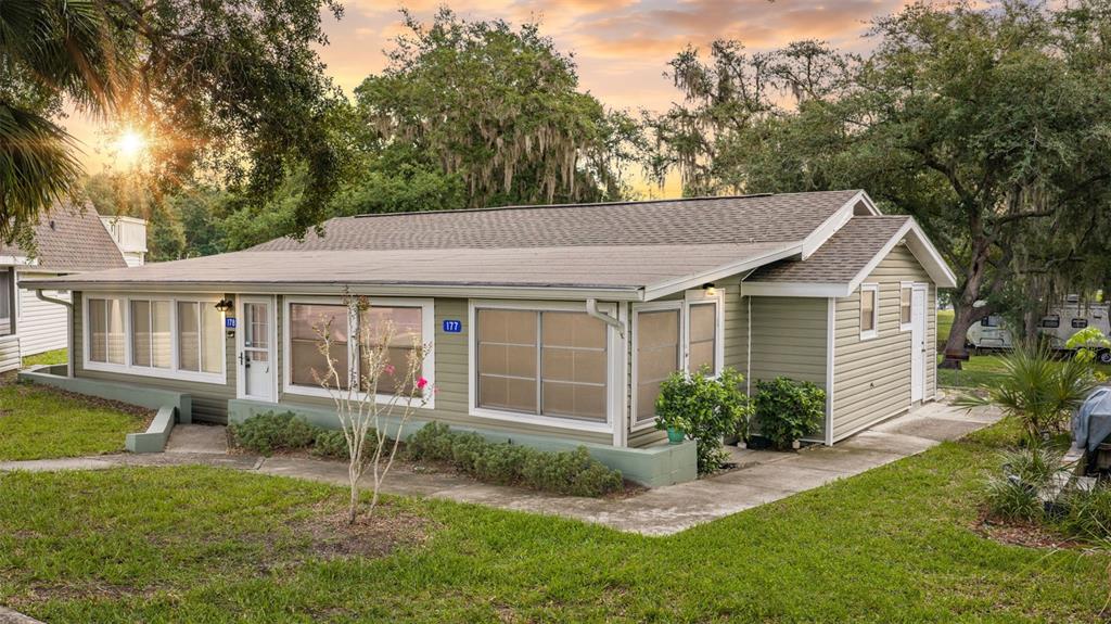 A single-story house with light green siding and large windows sits on a grassy lot — 10301 US HIGHWAY 27 UNIT 177, CLERMONT, FL
