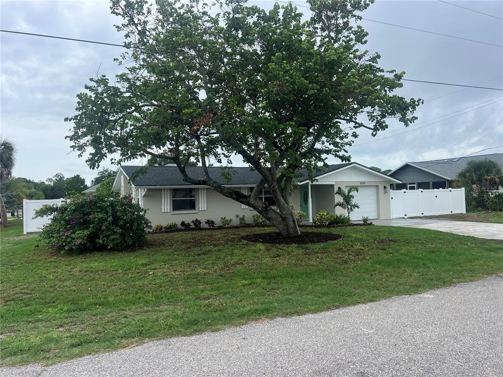 A single-story house with a large tree in the front yard and a white fence — 5270 CITADEL ROAD, VENICE, FL