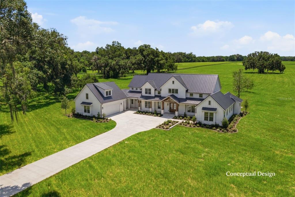This is a digital rendering of a modern farmhouse with a metal roof and driveway — TBD (Lot 14-W) SW 138TH LOOP, DUNNELLON, FL