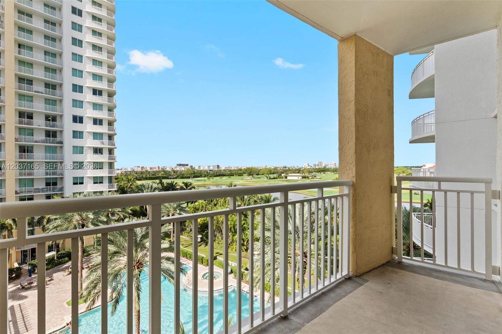 A balcony overlooks a swimming pool, palm trees, a golf course, and high-rise buildings — 1755 E Hallandale Beach Blvd # 501E, Hallandale Beach FL 33009, HALLANDALE BEACH, FL