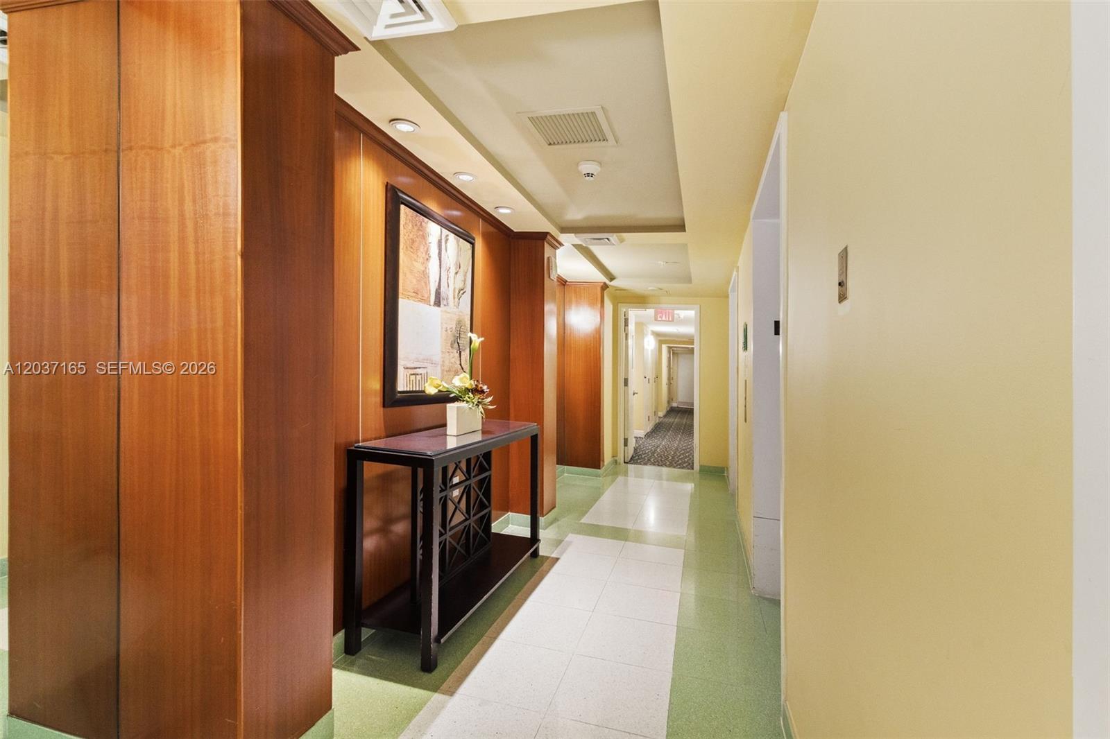 A hallway features wood-paneled walls, a console table with artwork, and light-colored tile flooring — 1755 E Hallandale Beach Blvd # 501E, Hallandale Beach FL 33009, HALLANDALE BEACH, FL