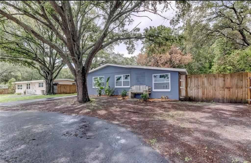 A living room with a television, a dining area, and a kitchen with white cabinetry — 6225 76TH AVENUE N, PINELLAS PARK, FL
