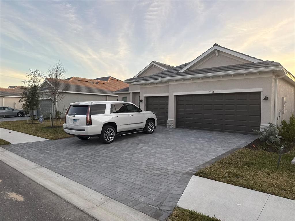 A white SUV is parked on a paved driveway in front of a suburban house — 7796 LAKES EDGE LANE, PORT CHARLOTTE, FL