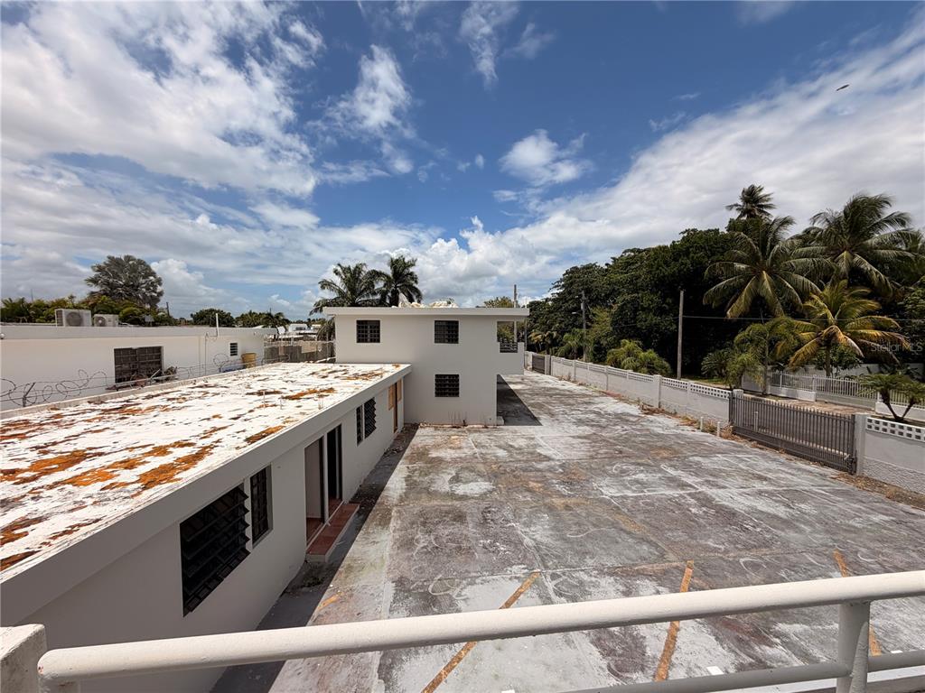 An elevated view shows a flat-roofed building with a large, paved parking lot — Calle E E UNIT 190, DORADO, PR