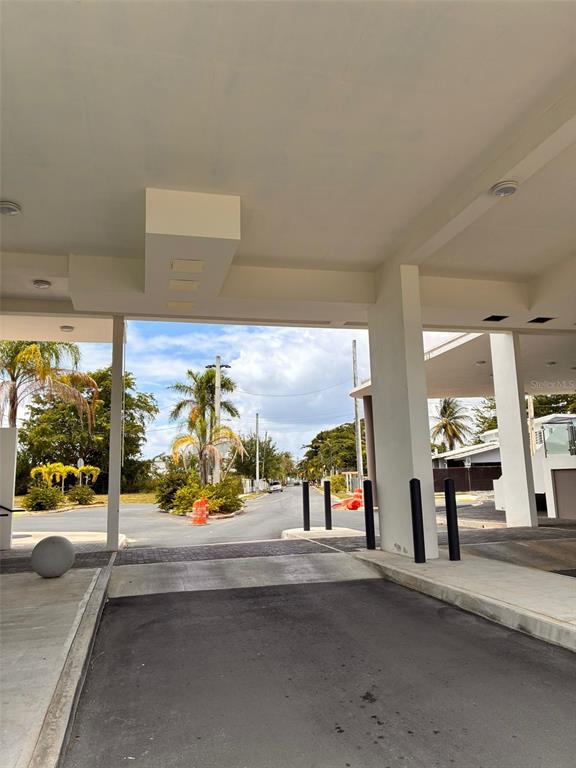 A covered driveway entrance leads to an outdoor street view with palm trees and landscaping — Calle E E UNIT 190, DORADO, PR