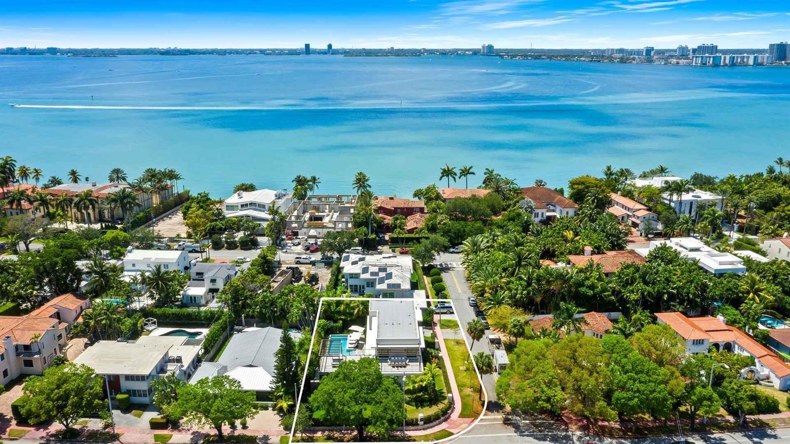An aerial view shows a modern house with a pool near a large body of water — 5288 Alton Road # 3, Miami Beach FL 33140, MIAMI BEACH, FL