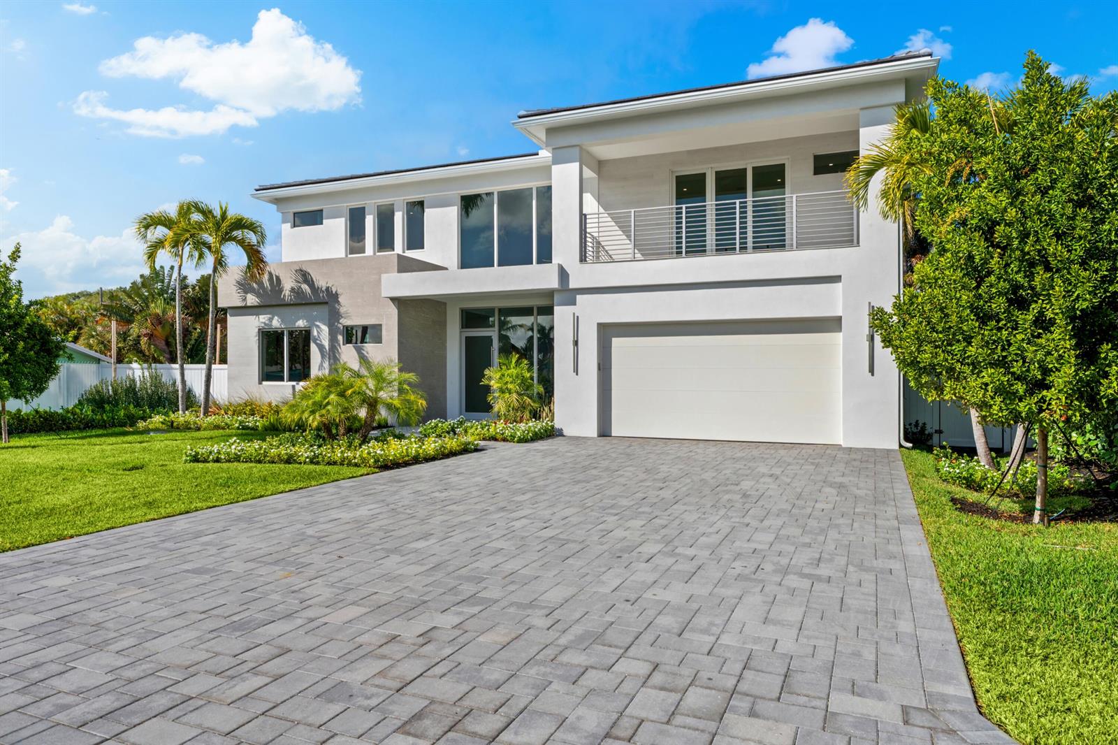 A modern two-story house with a paved driveway, a garage, and a second-floor balcony — 417 Lake Drive, Delray Beach FL 33444, DELRAY BEACH, FL