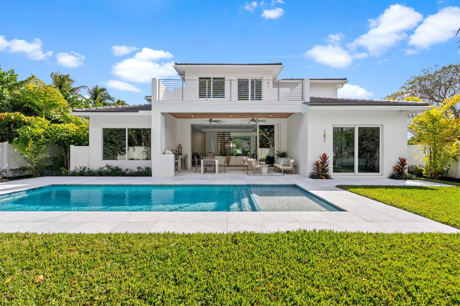 A modern white house with a swimming pool, patio, and second-story balcony under a sky — 417 Lake Drive, Delray Beach FL 33444, DELRAY BEACH, FL