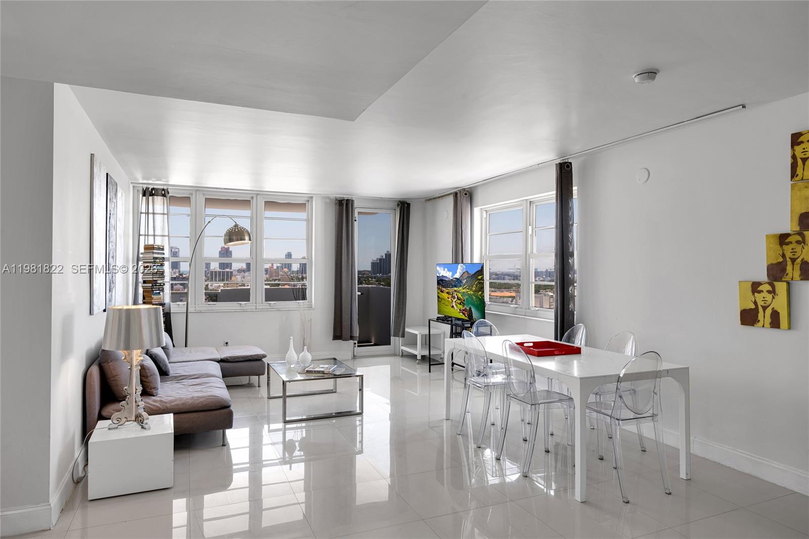 A bright living and dining area features white tile floors, large windows, and modern furniture — 100 Lincoln Rd # 1511, Miami Beach FL 33139, MIAMI BEACH, FL
