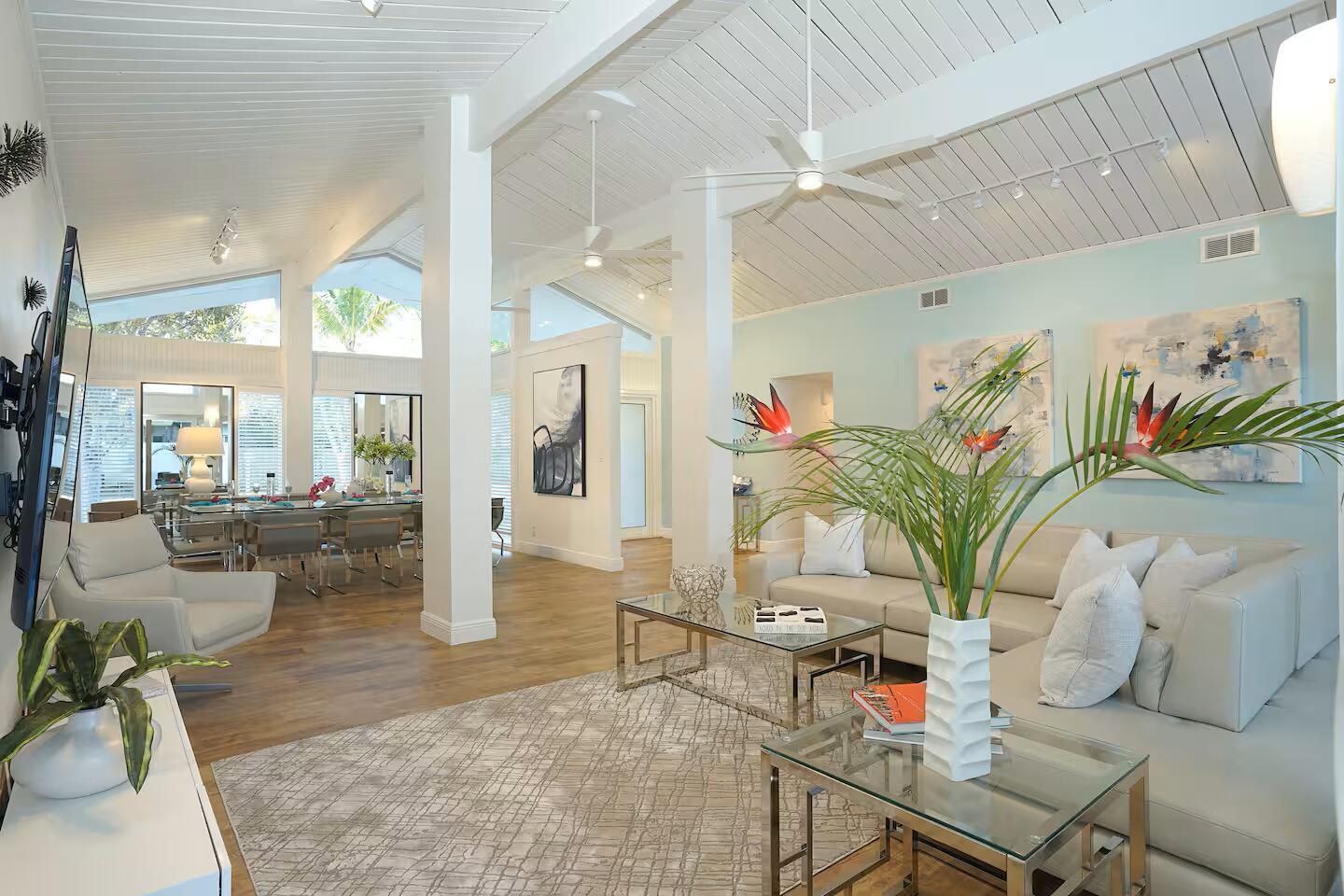 A bright, open-concept living and dining area features vaulted ceilings, light wood floors, and furniture — 1000 NE 8th Street, Pompano Beach FL 33060, POMPANO BEACH, FL