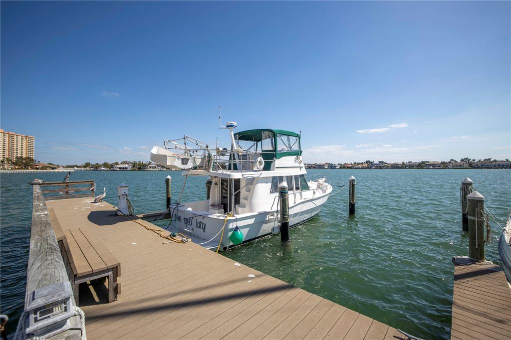 A white motor yacht is docked at a wooden pier on a sunny day — 5108 BRITTANY DRIVE S UNIT 204, ST PETERSBURG, FL