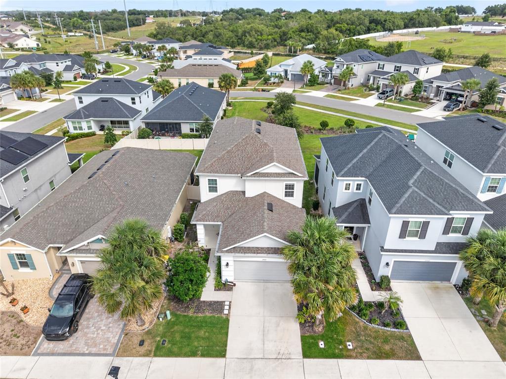 An aerial view shows a suburban neighborhood with several two-story houses and paved driveways — 2722 SURF TOP ROAD, CLERMONT, FL