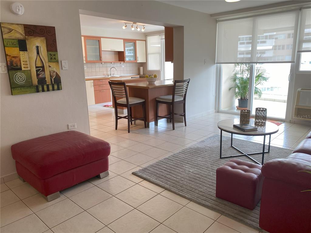 A living room with tile floors leads to an open kitchen with a dining island — 1020 DIAZ WAY STREET UNIT 720, CAROLINA, PR