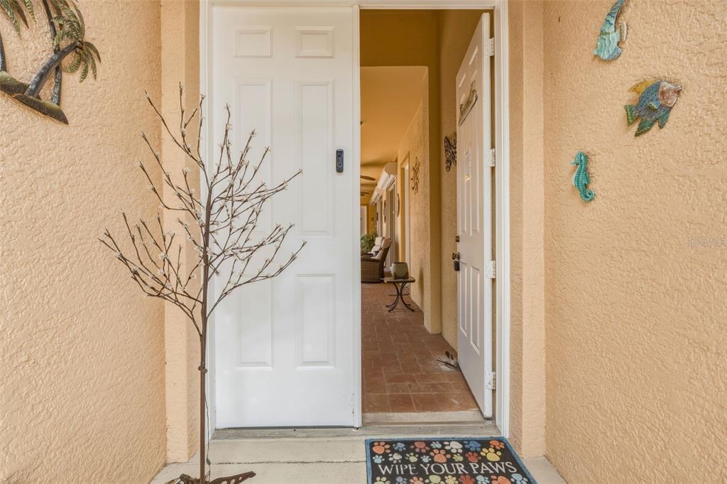 An open white front door reveals a tiled entryway with a small table and chairs — 13921 BENTLY CIRCLE, FORT MYERS, FL