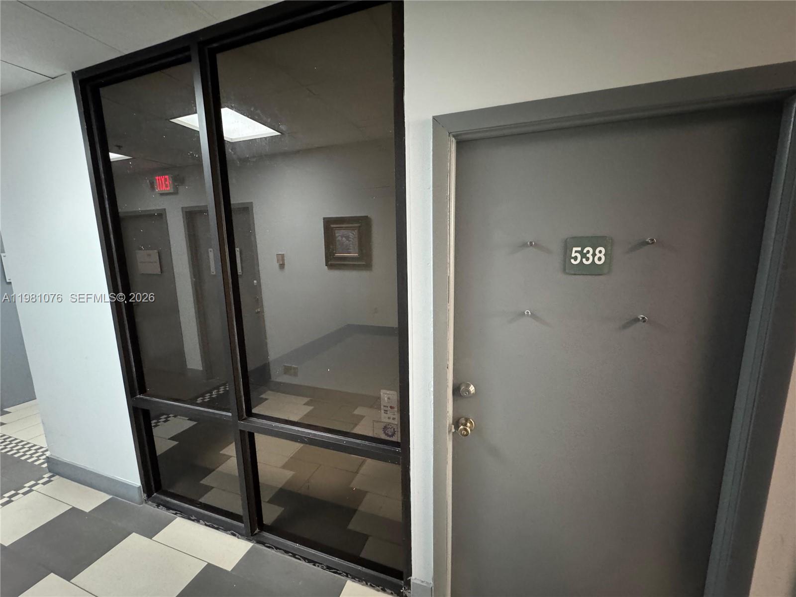 A gray door labeled 538 sits next to a large glass window in a hallway — 900 W 49th St Suite 538, Hialeah FL 33012, HIALEAH, FL