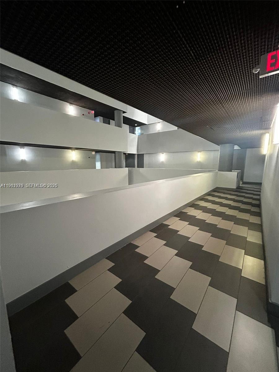 An indoor hallway with a tiled floor, white walls, and a dark grid ceiling — 900 W 49th St Suite 538, Hialeah FL 33012, HIALEAH, FL