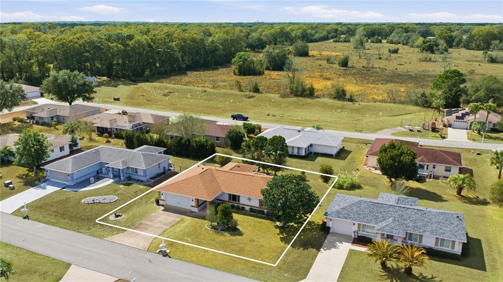 An aerial view of a suburban single-story house with a brown roof and a lawn — 9920 SW 63RD COURT, OCALA, FL
