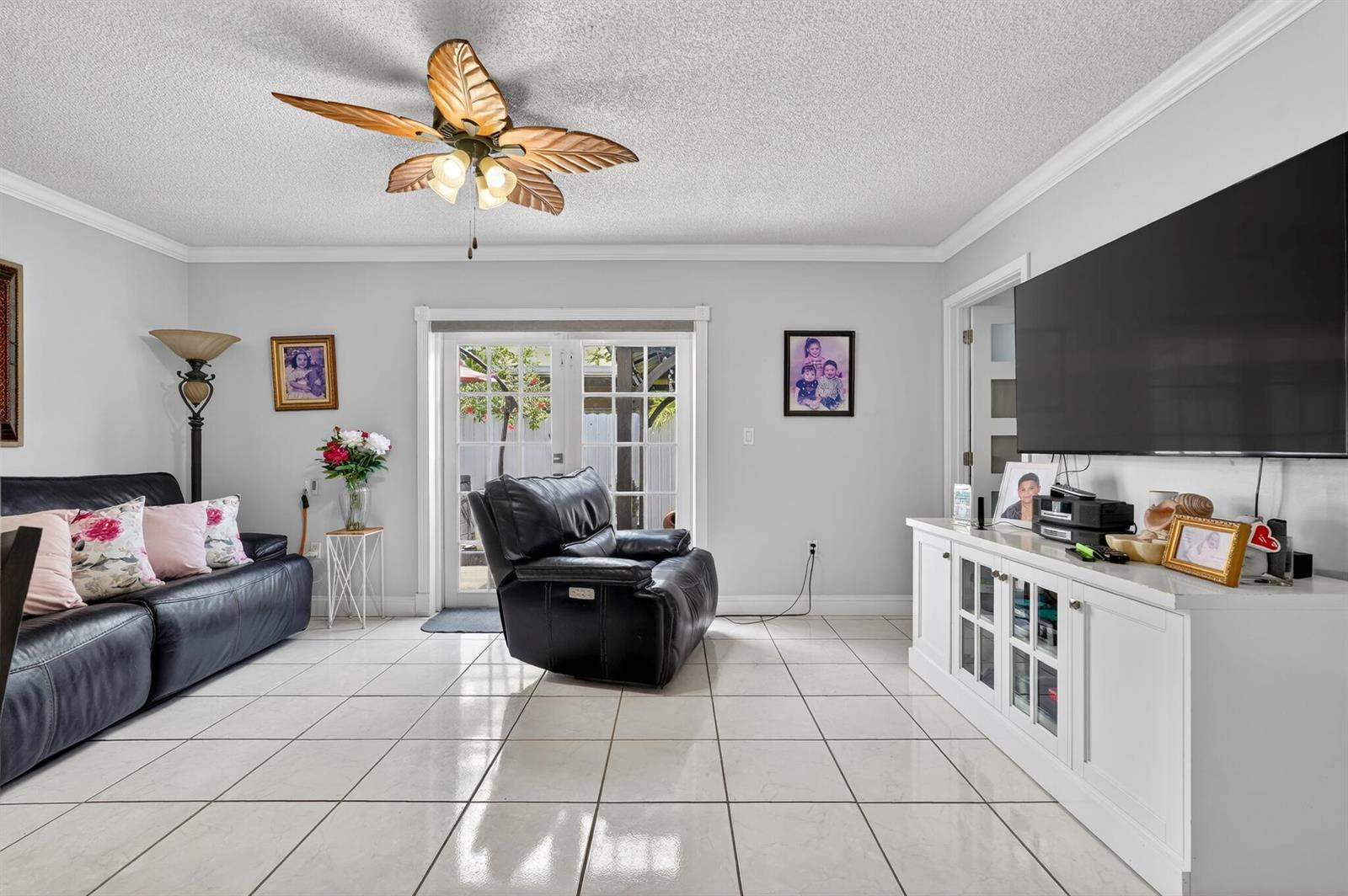 A living room features white tile floors, a ceiling fan, a sofa, and a television — 7101 W 24th Avenue # 45, Hialeah FL 33016, HIALEAH, FL