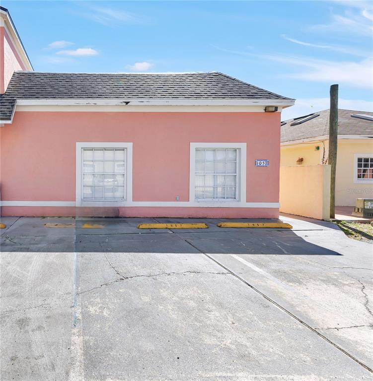 An aerial view shows a pink two-story building with a flat-roofed extension and parking — 1057 UNIVERSAL REST PLACE, KISSIMMEE, FL