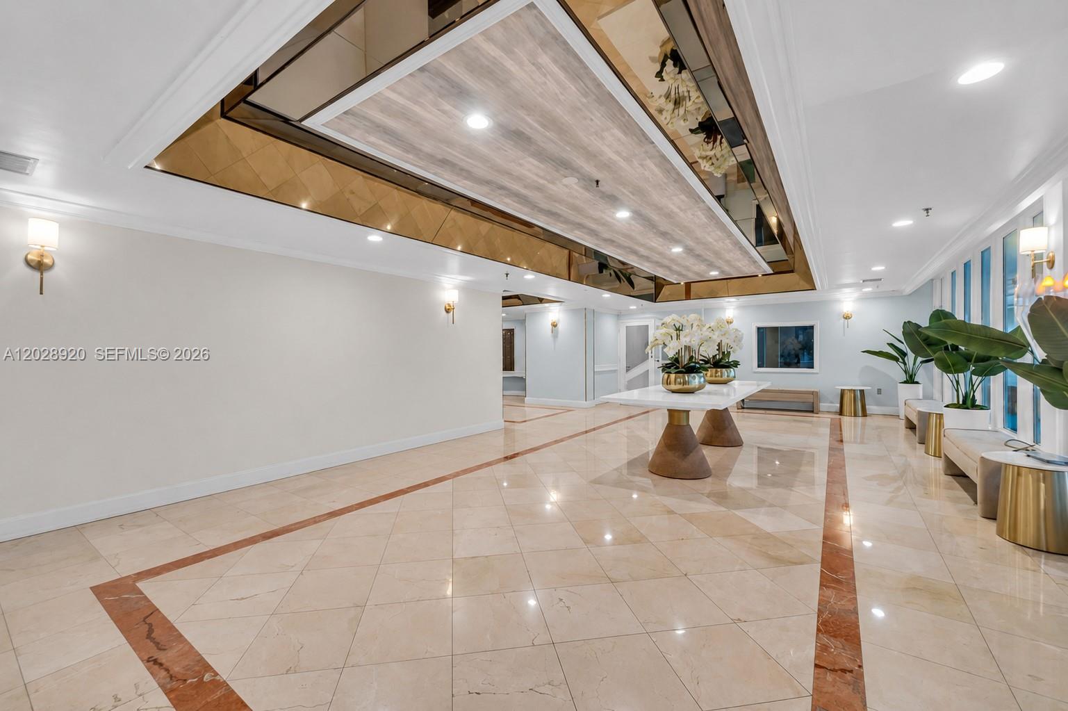 A spacious lobby features a large white table, marble floors, and a decorative ceiling inlay — 3200 Collins Ave # 8, Miami Beach FL 33140, MIAMI BEACH, FL