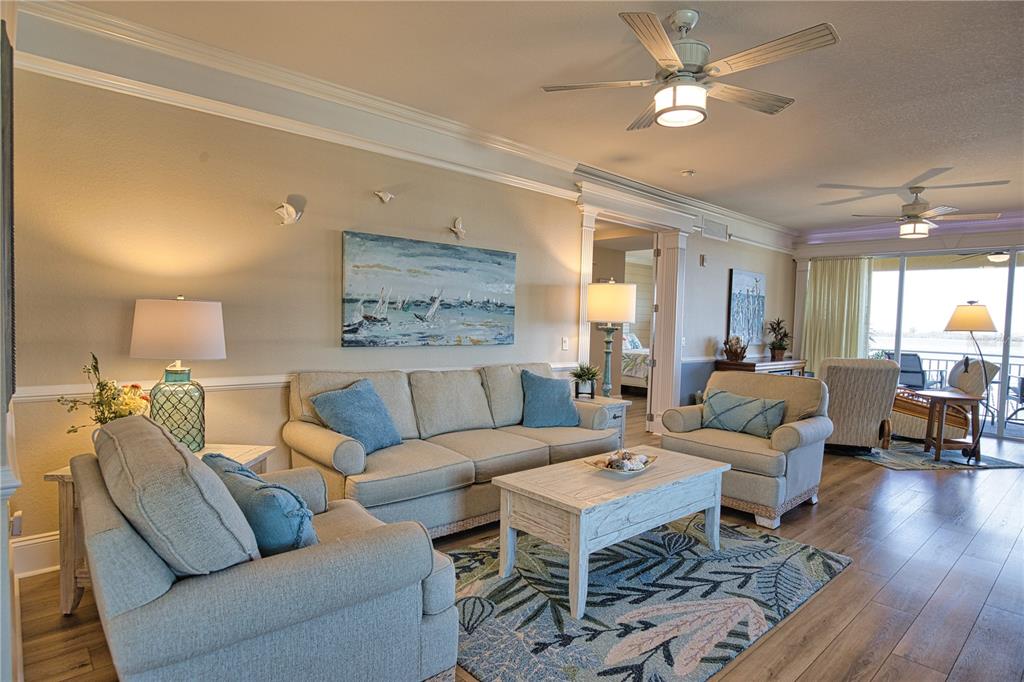 A living room features light-colored furniture, a patterned area rug, and a ceiling fan — 1116 S MCCALL ROAD UNIT 121, ENGLEWOOD, FL